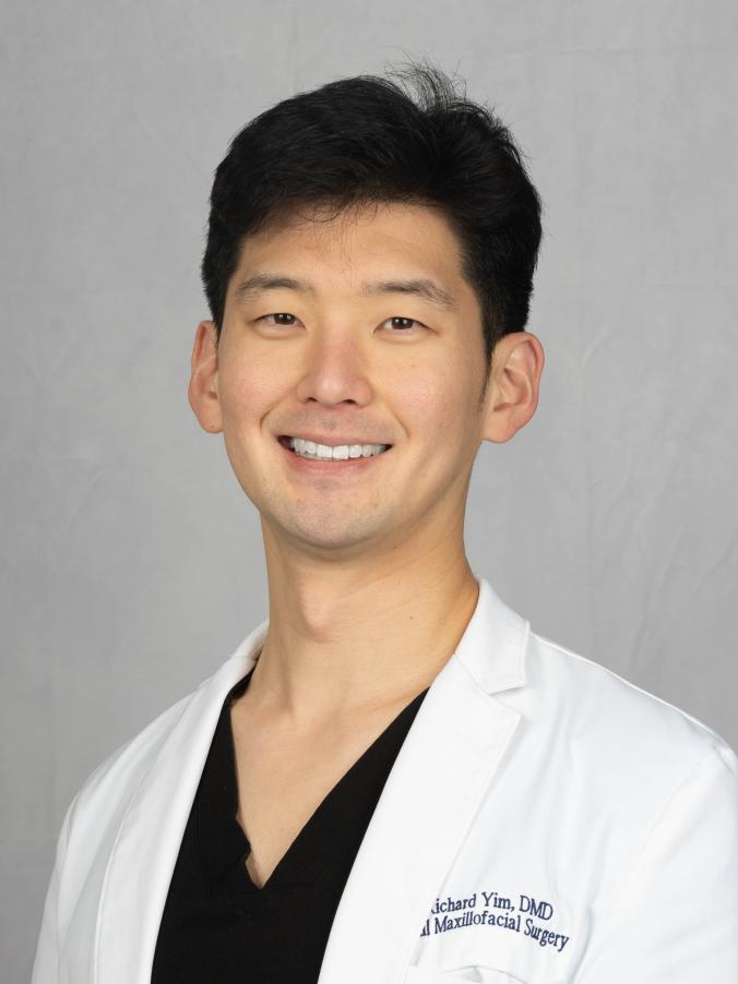 Richard Yim smiling in a white coat